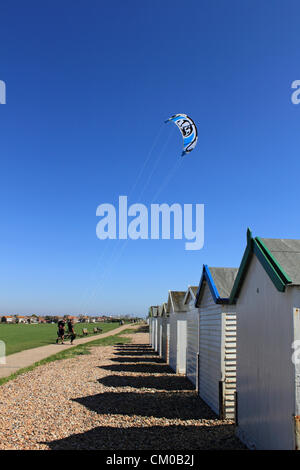 Göring Strand in der Nähe von Worthing, West Sussex, England, UK. Kitesurfer in Richtung Strand in den Spätsommer-Sonnenschein. Stockfoto