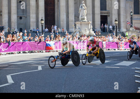 Passing St. Pauls Kathedrale in der City of London in der zweiten Runde ist Kurt Fearnley (Neuseeland), der Bronze Bedal, Foilowed von Schweizer Marcel Hug gewann die Silbermedaille mit Team GB David Weir auf rechten Seite, die Goldmedaille. Stockfoto