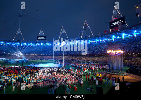 Athleten drängen das Feld vor Olympia Kessel erloschen ist, bei der Abschlussfeier der Paralympischen Spiele 2012 in London Stockfoto