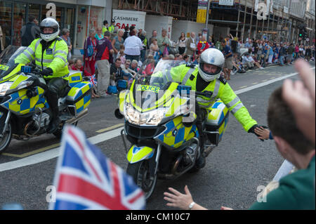 Ein Polizist gibt ein Mitglied der Öffentlichkeit ein high Five im Team GB Parade London 10. September 2012.  Tausende von Menschen besuchte die Feierlichkeiten in Partystimmung, wie 21 offene Spitzenfahrzeuge Sportler durch die Stadt getragen. Stockfoto