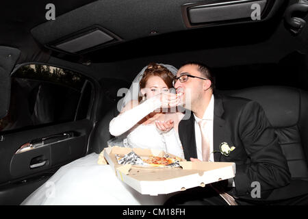 Braut und Bräutigam Essen Pizza in der limousine Stockfoto