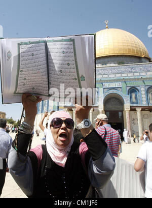 14. September 2012 - Jerusalem, Jerusalem, Palästina - A palästinensische Frau eine Kopie des Koran während einer Demonstration gegen den umstrittenen Film "Die Unschuld der Muslime" vor al-Aqsa Mosqe in Jerusalem, am 14. September 2012 hält. Der umstrittene low-Budget-Film angeblich durch eine israelisch-amerikanische die Muslime als unmoralisch darstellt und grundlose, löste Wut in Libyen, wo vier Amerikaner, darunter des Botschafters am Dienstag wenn ein Mob angegriffen das US-Konsulat in Benghazi getötet wurden, und führte zu Protesten außerhalb US-Missionen in Marokko, Sudan, Ägypten, Tunesien und Stockfoto