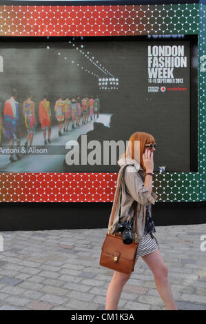 Somerste House, London, UK. 14. September 2012. Ein Besucher der Veranstaltung vor die große Leinwand. London Fashion Week 2012 eröffnet heute im Somerset House. Die zweimal jährliche Show ist einer der Mode weltweit großen vier neben Paris, Mailand und New York. Bildnachweis: Matthew Chattle / Alamy Live News Stockfoto