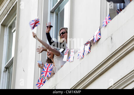 Glasgow, Freitag, 14. September 2012. Menschen beobachten aus einem Fenster bei Schottlands Team GB 2012 Olympiateilnehmer und Paralympier, die an der Parade in Glasgow, Schottland, Großbritannien, teilnehmen Stockfoto