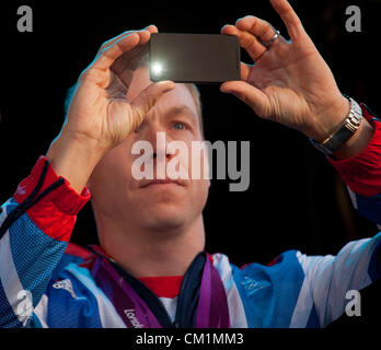 14. September 2012. Der Blitz erlischt als Sir Chris Hoy, Team GB größte jemals Olympian, nimmt ein Foto von der Masse am Ende der Heimkehr parade zu Ehren Schottlands Olympioniken und Paralympioniken in George Square, Glasgow. Stockfoto