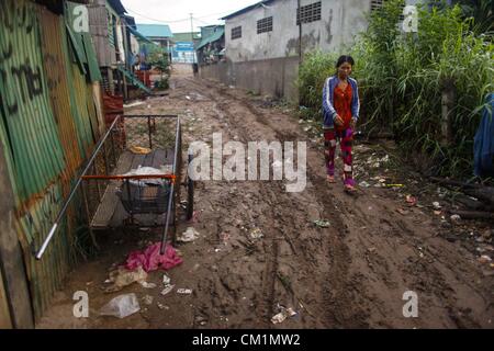 15. September 2012 - Phnom Penh, Kambodscha - geht eine kambodschanische Frau eine schlammige Gasse in der Nähe ein Elendsviertel entlang des Mekong Samstag, 15. September 2012, in der Nähe von Phnom Penh, Kambodscha.  Die täglichen Leben der viele Kambodschaner ist an den Tonle Sap und Mekong Flüsse gebunden. (Kredit-Bild: © David Longstreath/ZUMAPRESS.com) Stockfoto