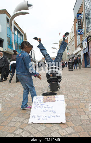 Blackpool, UK. Samstag, 15. September 2012. Blackpool Mann dreht den Kopf nach unten Wirtschaft zu seinem Vorteil.  "Upside down Andy" machen ein Leben steht auf dem Kopf stehend mit dem Kopf in einen Eimer zur Belustigung von Käufern in Blackpool Stadtzentrum entfernt. Stockfoto