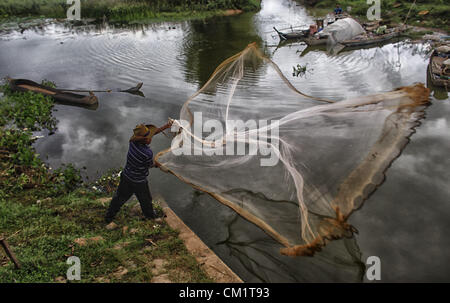 15. September 2012 - Phnom Penh, Kambodscha - warf ein kambodschanischer Fischer sein Netz in Teich Wasser am Stadtrand von Phnom Penh, Kambodscha, Samstag, 15. September 2012.  Kambodscha ist eines der ärmsten Länder in Südostasien. (Kredit-Bild: © David Longstreath/ZUMAPRESS.com) Stockfoto