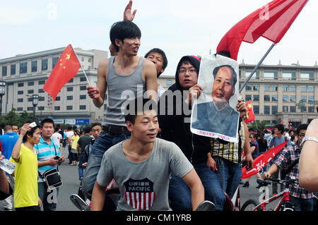 Xian, China. Samstag, 15. September 2012. Anti-japanischen Demonstranten mit roten Fahnen und Vorsitzenden Mao-Porträt während einer Demonstration am Glockenturm in Xi ' an, China, auf Samstag, 15. September 2012 laufen. Kämpfe brach zwischen Demonstranten und Polizei während eines Marsches von mehr als 10.000 Studenten, die an die Souveränität der Fischerei Islands(Diaoyu Islands) protestierten. Stockfoto