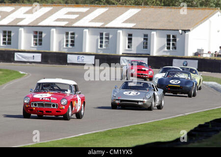 Goodwood Estate, Chichester, UK. 15. September 2012. Joe Bamford fahren ein 1963 MGB (Nr. 12) wird gejagt von Cameron Healy in Silber 1965 Porsche 904/6 Carrera GTS während der Fordwater Trophy beim Goodwood Revival.  Die Wiederbelebung ist eine "magische Schritt zurück in die Zeit", präsentiert eine Mischung aus Autos und Luftfahrt aus den 40's, 50er und 60er Jahre und ist eines der beliebtesten historischen Motorsport-Ereignisse in der Welt. Besuchen Sie für weitere Informationen www.goodwood.co.uk/revival. Stockfoto