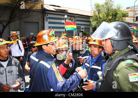 LA PAZ, Bolivien, 18. September 2012. Kooperative Bergleute argumentieren mit der Polizei während eines Marsches zu verlangen, dass die Regierung mit dem Versprechen geben ihnen einen größeren Anteil an die Konzession für die Colquiri entspricht mir in der Nähe von Oruro. Genossenschaft und Angestellte Bergleute, die für die staatliche Bergbaugesellschaft COMIBOL arbeiten haben Kontrolle über die Mine für mehrere Wochen mit Protesten eskaliert in der letzten Woche bestreiten wurde. Die Angestellten Bergleute fordern die Mine verstaatlicht und die Genossenschaften daran hinderte, dort zu arbeiten. Stockfoto