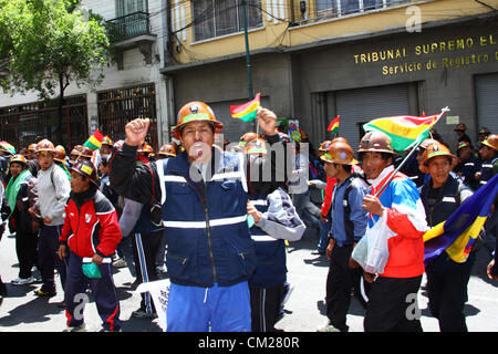 LA PAZ, Bolivien, 18. September 2012. Ein kooperatives Bergmann schreit Beleidigungen bei der Polizei und Staat bezahlten Bergleute während eines Marsches auf Nachfrage der Regierung erfüllt versprechen ihnen einen größeren Anteil an die Konzession für die Colquiri geben mir in der Nähe von Oruro. Genossenschaft und Angestellte Bergleute, die für die staatliche Bergbaugesellschaft COMIBOL arbeiten haben Kontrolle über die Mine für mehrere Wochen mit Protesten eskaliert in der letzten Woche bestreiten wurde. Die Angestellten Bergleute fordern die Mine verstaatlicht und die Genossenschaften daran hinderte, dort zu arbeiten. Stockfoto