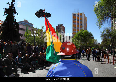 LA PAZ, BOLIVIEN, 19. September 2012. Mitglieder der FSTMB (Federación Sindical de Trabajadores Mineros de Bolivia, ein Verband staatlich angestellter Bergleute) halten vor ihrem Büro eine Mahnwache in der zentralen Av 16 de Julio/El Prado-Straße für ihren Kollegen Héctor Choque ab. die an Verletzungen durch Dynamit-Sprengungen starben, die gestern während eines protestmarsches von kooperativen Bergleuten, der gewalttätig wurde, erlitten haben. Stockfoto