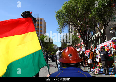 LA PAZ, BOLIVIEN, 19. September 2012. Mitglieder der FSTMB (Federación Sindical de Trabajadores Mineros de Bolivia, ein Verband staatlich angestellter Bergleute) halten vor ihrem Büro eine Mahnwache in der zentralen Av 16 de Julio/El Prado-Straße für ihren Kollegen Héctor Choque ab. die an Verletzungen durch Dynamit-Sprengungen starben, die gestern während eines protestmarsches von kooperativen Bergleuten, der gewalttätig wurde, erlitten haben. Stockfoto