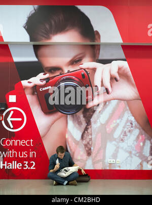 Besucher sitzen vor großen Plakat Werbung neue Canon-Kamera am zweiten Tag der halbjährlich stattfindenden Photokina Fotografie und imaging-Messe statt in Köln; Mittwoch, 19. September 2012. Stockfoto