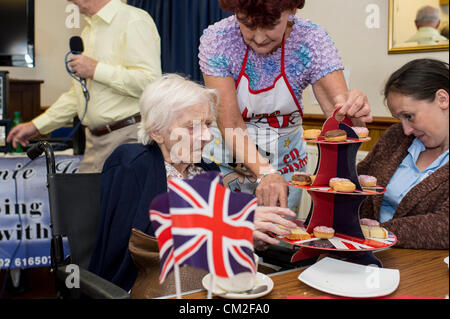 20. September 2012. Leigh on Sea, Essex, England. Die sechsten jährlichen Centenarian Tea Party organisiert von Southend konservative Wartungstafel, David Amess. 14 hundertjährigen besuchte die Conservative Club am Leigh für eine Tee-Party. 2009 sah 29 teilnehmen, die ihren Datensatz so weit ist. Doris Meddle, wählt 101 Jahre alt, einen Kuchen aus einer der Helfer. Der älteste Teilnehmer war heute Ivy Marshall, 104 Jahre alt. Stockfoto