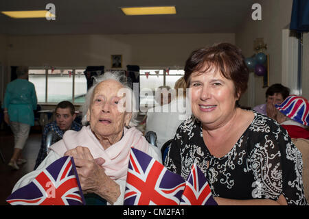 20. September 2012. Leigh on Sea, Essex, England. Die sechsten jährlichen Centenarian Tea Party organisiert von Southend konservative Wartungstafel, David Amess. 14 hundertjährigen besuchte die Conservative Club am Leigh für eine Tee-Party. 2009 sah 29 teilnehmen, die ihren Datensatz so weit ist.  Essie Glauda, 103 Jahre alt, genießt einen Song mit ihrer Tochter. Stockfoto