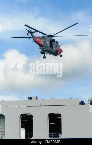 Bangor, County Down. 23.09.2012 - schwebt Royal Navy Sea King Hubschrauber Rettung 177 über einem angeschlagenen Fähre während einer Übung Stockfoto