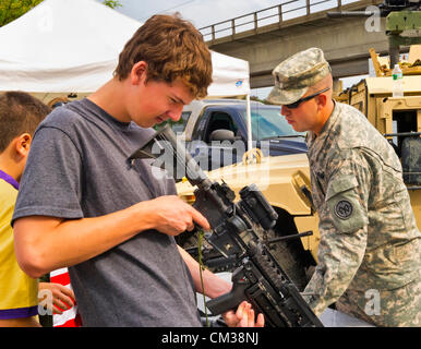 22. September 2012 - Bellmore, New York USA - A Teen Boy durchsucht Anwendungsbereich Maschinengewehr im Bereich US Army Military Expo Abschnitts am 26. jährlichen Bellmore Familie Street Festival. Stockfoto