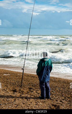 25. September 2012. Strand von Brighton, Sussex, UK. Starker Wind am Meer in Brighton weckt und bringt regelmäßig kräftige Schauer entlang der Südküste. Ein einsamer Angler steht mit seinem Stab am Strand. Stockfoto