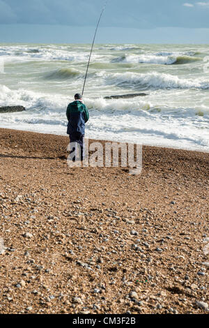 25. September 2012. Strand von Brighton, Sussex, UK. Starker Wind am Meer in Brighton weckt und bringt regelmäßig kräftige Schauer entlang der Südküste. Ein einsamer Angler steht mit seinem Stab am Strand. Stockfoto