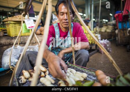 26. September 2012 - Bangkok, Thailand - verkaeufers Gegrillte Banane bei der Arbeit in Khlong Toey Markt in Bangkok. Khlong Toey (auch genannt Khlong Toei) Markt ist einer der größten '' nass Märkte '' in Thailand. Der Markt befindet sich mitten in einem von Bangkoks größten Slum-Gebieten und in der Nähe von ursprünglichen Tiefwasser-Hafen der Stadt. Tausende von Menschen leben in der benachbarten Slum-Gegend. Tausende Einkaufen mehr in den weitläufigen Markt für frisches Obst und Gemüse sowie Fleisch, Fisch und Geflügel. (Bild Kredit: Jack Kurtz/ZUMAPRESS.com ©) Stockfoto