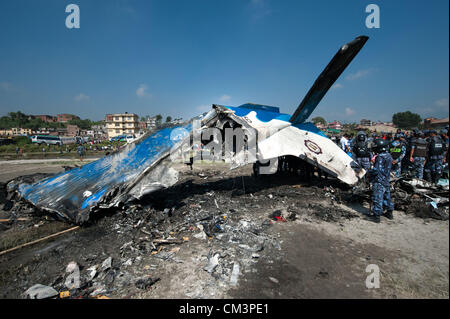 28. September 2012 - Kathmandu, Kathmandu, Nepal - Nepal A Polizisten herumstehen Wrack des Flugzeugs SITA Luft an der Absturzstelle. Ein Flugzeug mit Wanderern in der Everest Region stürzte kurz nach dem Start am Freitagmorgen in Nepals Hauptstadt, tötete alle 19 Menschen an Bord. Opfer sind sieben Briten, fünf chinesische und vier Nepali. Die zweimotorige Propellermaschine Zugehörigkeit zu Sita Inlandsflüge stürzte auf offenes Gelände nahe dem Fluss Manohara am südwestlichen Rand des Katmandu. Das Wetter morgen war klar. Der Herbst ist die Hochsaison für Tourismus in Nepal. Stockfoto