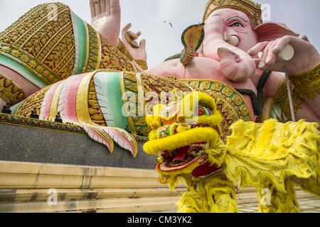 29. September 2012 - Nakorn Nayok, Nakorn Nayok, Thailand - Thai-chinesischen Stil Löwen vor einer Statur von Ganesh während Gedenktage von Ganesh Ustav am Wat Utthayan Ganesh, ein Tempel gewidmet Ganesh in Nakorn Nayok, etwa drei Stunden von Bangkok Tänzer. Viele Thai-Buddhisten integrieren hinduistische Elemente, einschließlich der Verehrung von Ganesh in ihrem geistlichen Leben. Ganesha Chaturthi Alias Vinayaka Chaturthi, ist am Tag der Wiedergeburt von Lord Ganesha, der Sohn von Shiva und Parvati das hinduistische Festival gefeiert. Das Festival, auch bekannt als Ganeshotsav ("fest des Ganesha'') ist Schaﬀ Stockfoto