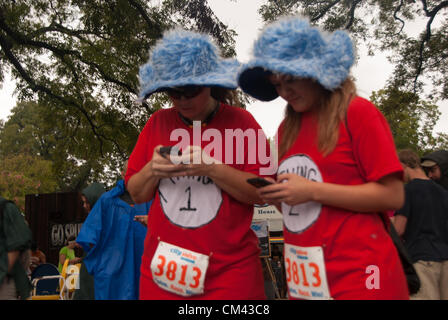 29. September 2012 San Antonio, Texas, USA - Janet Dudley (l) und Sarah Carreon ihre Smartphones verwenden, um Hinweise im CitySolve Urban Rennen in San Antonio zu lösen. Trotz starkem Regen nahmen mehr als 20 Teams von 2-4 Personen im Rennen. Stockfoto