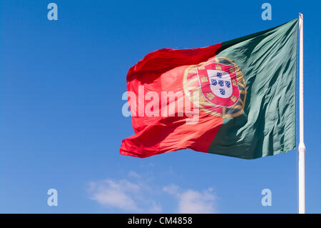 Portugiesische Flagge gegen sonnigen blauen Himmel winken im Wind Stockfoto