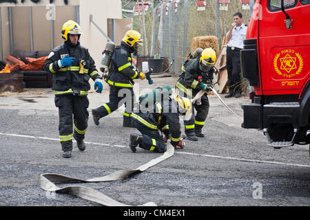 Jerusalem, Israel. 2. Oktober 2012. Feuerwehrleute zeigen schnelle Notfall Bereitstellung, Brandbekämpfung und Evakuierung, da Jerusalem Feuerwehr seine Türen für die Öffentlichkeit öffnet.  Jerusalem, Israel. 2. Oktober 2012.  Jerusalem-Feuerwehr öffnet seine Türen für die Öffentlichkeit in Givat Mordechai Station ermöglicht der Öffentlichkeit, die Arbeit der Feuerwehrleute aus nächster Nähe zu sehen. Die Jerusalem-Feuerwehr entspricht jährlich mehr als 8.000 Veranstaltungen. Stockfoto