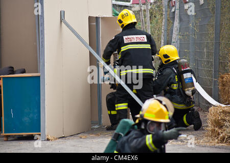 Jerusalem, Israel. 2. Oktober 2012. Feuerwehrleute zeigen schnelle Notfall Bereitstellung, Brandbekämpfung und Evakuierung, da Jerusalem Feuerwehr seine Türen für die Öffentlichkeit öffnet.  Jerusalem, Israel. 2. Oktober 2012.  Jerusalem-Feuerwehr öffnet seine Türen für die Öffentlichkeit in Givat Mordechai Station ermöglicht der Öffentlichkeit, die Arbeit der Feuerwehrleute aus nächster Nähe zu sehen. Die Jerusalem-Feuerwehr entspricht jährlich mehr als 8.000 Veranstaltungen. Stockfoto