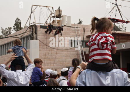 Jerusalem, Israel. 2. Oktober 2012. Kinder sehen, wie Feuerwehrleute Abseilen von einem Dach zeigen, wie Jerusalem Feuerwehr seine Türen für die Öffentlichkeit öffnet. Jerusalem, Israel. 2. Oktober 2012.  Jerusalem-Feuerwehr öffnet seine Türen für die Öffentlichkeit in Givat Mordechai Station ermöglicht der Öffentlichkeit, die Arbeit der Feuerwehrleute aus nächster Nähe zu sehen. Die Jerusalem-Feuerwehr entspricht jährlich mehr als 8.000 Veranstaltungen. Stockfoto