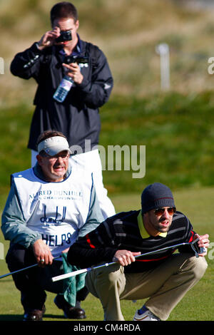 4. Oktober 2012. Ein Beamter der Kurs nimmt ein Foto von Michael Phelps, wie er sich einen Putt Linien, während in der Europäischen Tour Alfred Dunhill Links Championship Golf-Turnier, gespielt auf dem Carnoustie Golf Course im Wettbewerb. Obligatorische Kredit: Mitchell Gunn/ESPA Stockfoto