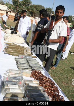 CID Polizei, die Beamten zu inspizieren beschlagnahmte Waffen, Kugeln und explosive Stoffe, die während der Pressekonferenz in CID-Büro in Karachi auf Freitag, 5. Oktober 2012 in einem Raid wiederhergestellt wurden. CID Polizei verhaftete sieben mutmaßliche Terroristen, darunter ein Ameer verbotenen Outfit und wiederhergestellten riesige Menge von Sprengstoff und Waffen. Stockfoto