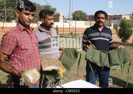 CID Polizei, die Beamten zu inspizieren beschlagnahmte Waffen, Kugeln und explosive Stoffe, die während der Pressekonferenz in CID-Büro in Karachi auf Freitag, 5. Oktober 2012 in einem Raid wiederhergestellt wurden. CID Polizei verhaftete sieben mutmaßliche Terroristen, darunter ein Ameer verbotenen Outfit und wiederhergestellten riesige Menge von Sprengstoff und Waffen. Stockfoto