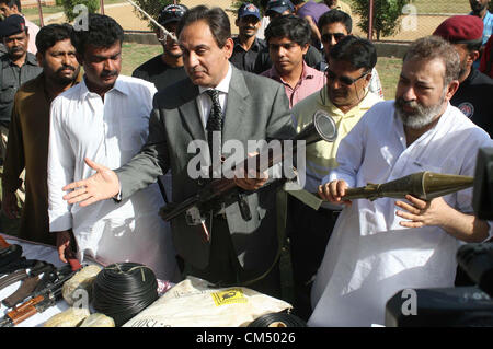 CID Polizei, die Beamten zu inspizieren beschlagnahmte Waffen, Kugeln und explosive Stoffe, die während der Pressekonferenz in CID-Büro in Karachi auf Freitag, 5. Oktober 2012 in einem Raid wiederhergestellt wurden. CID Polizei verhaftete sieben mutmaßliche Terroristen, darunter ein Ameer verbotenen Outfit und wiederhergestellten riesige Menge von Sprengstoff und Waffen. Stockfoto