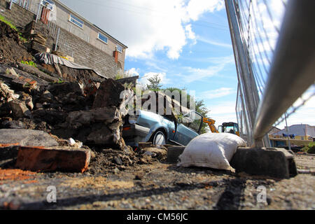 Swansea, Vereinigtes Königreich, Samstag, 6. Oktober 2012.  Einen alten VW Polo war das einzige Opfer nach eine Stützmauer in Swansea zusammengebrochen. Die Straße wurde geschlossen und vier Häuser evakuiert nach dem Erdrutsch in der St. Thomas-Viertel der Stadt in den frühen Morgenstunden.   Verletzt wurde niemand bei dem Vorfall Beaumont Crescent bei 04:20 am Samstag.   Aber South Wales Police Menschen vorsorglich evakuiert. Sie bleiben mit Freunden und Familie während des Rates Arbeiter die Website sicher machen. Stockfoto