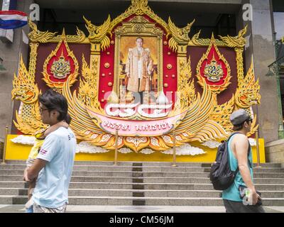 7. Oktober 2012 wird ein Porträt von Bhumibol Adulyadej, der König von Thailand vor dem C.P.-Turm in Bangkok - Bangkok, Thailand - Leute vorbeigehen. Bhumibol Adulyadej ist der amtierende König von Thailand. Er ist bekannt als Rama IX. Er regierte seit 9. Juni 1946, ist er der weltweit am längsten amtierende Staatsoberhaupt aktuelle und der am längsten regierende Monarch in der thailändischen Geschichte. Er wird von den Thais verehrt seinen Geburtstag 5 Dezember ist ein nationaler Feiertag und wird auch in Thailand als Vatertag gefeiert. Wie nähert sich der Geburtstag des Königs, in Aufmachungen Unternehmen riesige Porträts des Königs vor ihrer Bui Stockfoto