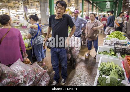 9. Oktober 2012 arbeitet in der Blumenmarkt Bangkok - Bangkok, Thailand - A-Porter. Träger werden Blumen von Stall zu Stall bewegen und hilft Kunden ihre Einkäufe raus zu wartenden Autos und Taxis eingesetzt. Bangkok Blumenmarkt (Pak Klong Talad) ist die größte groß- und Einzelhandel frische Blumenmarkt in Bangkok. Es ist auch eines der größten frisches Obst und Gemüsemärkte in der Stadt. Der Markt befindet sich im alten Teil der Stadt, südlich von Wat Po (Tempel des liegenden Buddha) und dem Grand Palace. (Bild Kredit: Jack Kurtz/ZUMAPRESS.com ©) Stockfoto