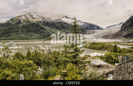 5. Juli 2012 - wird von einem Touristen Borough von Juneau, Alaska, USA - Mendenhall Gletscher und Mendenhall Lake, umgeben von den majestätischen Coast Mountain Range von Mendenhall Gletscher Visitor Center (rechts) fotografiert. Ab 1951â€ "1958 zogen die Endstation des Gletschers, mündet in Mendenhall Lake von seiner Quelle 12 Meilen von Juneau-Lcefield, 1.900 Metern 580Â. Seit 1958 hat es 1,75 Meilen (2.82Â km) zurück, wenn Mendenhall Lake entstand. Eisberge schwimmen auf der Oberfläche des Sees. Mehr als 350.000 Menschen Jahr besuchen um zu sehen, sein Gesicht, eine Wand mehr als 100 Fuß hoch und eine Meile wi Stockfoto