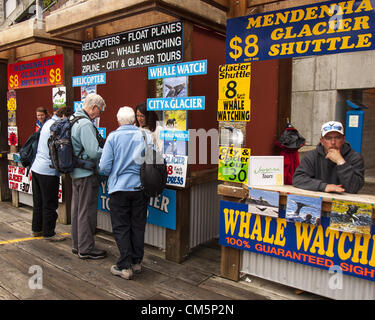 5. Juli 2012 - Borough Of Juneau, Alaska, US - Kreuzfahrtschiff Passagiere an einem Kiosk an der Uferpromenade in Juneauâ€™ s Cruise Terminal Kauf einer Tour. Kioske werben Meeresleben, Gletschertouren und Hubschrauber und Schwimmer Flugzeug-Touren für Touristen. (Kredit-Bild: © Arnold Drapkin/ZUMAPRESS.com) Stockfoto