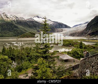 5. Juli 2012 - wird von einem Touristen Borough von Juneau, Alaska, USA - Mendenhall Gletscher und Mendenhall Lake, umgeben von den majestätischen Coast Mountain Range von Mendenhall Gletscher Visitor Center (rechts) fotografiert. Ab 1951â€ "1958 zogen die Endstation des Gletschers, mündet in Mendenhall Lake von seiner Quelle 12 Meilen von Juneau-Lcefield, 1.900 Metern 580Â. Seit 1958 hat es 1,75 Meilen (2.82Â km) zurück, wenn Mendenhall Lake entstand. Eisberge schwimmen auf der Oberfläche des Sees. Mehr als 350.000 Menschen Jahr besuchen um zu sehen, sein Gesicht, eine Wand mehr als 100 Fuß hoch und eine Meile wi Stockfoto