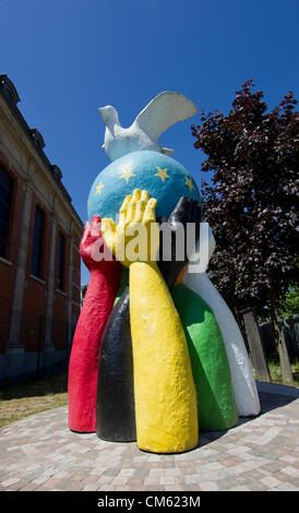 Frieden-Statue eines Globus mit der EU-Flagge gemalt und eine Friedenstaube steht im Garten einer Kirche in der Nähe des EU-Rates in Brüssel Stockfoto