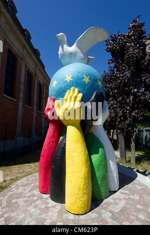 Frieden-Statue eines Globus mit der EU-Flagge gemalt und eine Friedenstaube steht im Garten einer Kirche in der Nähe des EU-Rates in Brüssel Stockfoto