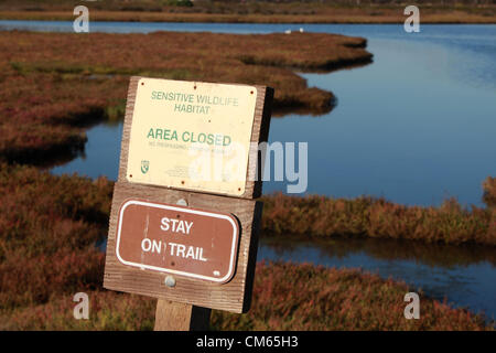 13. Oktober 2012 - Huntington Beach, Kalifornien, USA - Schild "sensible Tierwelt Lebensraum, Bereich geschlossen, auf Spur bleiben. Gremium billigt 111 Häuser in der Nähe von Bolsa Chica Feuchtgebiete. Parkside Estates gehören Einfamilienhäuser, Parkplatz, Wanderwege und Feuchtgebiete in Huntington Beach nach California Coastal Kommission Genehmigung. Bolsa Chica ökologische Reserve ist ein Naturschutzgebiet in der Stadt von Huntington Beach. Es wird durch das Kalifornien Abteilung von Fish and Game bezeichnet, eine Küstenstadt Feuchtgebiet mit seinen Wohnsitz bedrohten und gefährdeten Arten zu schützen. "Bolsa Chica" bedeutet "Säckchen" in Spanisch Stockfoto