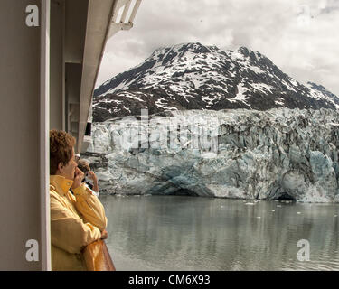 3. Juli 2012 - Gletscher-Bucht, Alaska, USA - Passagiere Kreuzfahrt im Glacier-Bay die beeindruckende Lamplugh Gletscher von den Balkonen auf Holland America Lines ms Zaandam anzeigen. Mit Ursprung in der Brady Icefield Gletscher erstreckt sich über 16 Meilen (26Â km) und hat eine breite von etwa 0,75 Meilen (1.21Â km) an der Wasser-Fläche und steigt bis in Höhen von 150â€ "160 Fuß (46â€"49 m). Glacier Bay umfasst 3,3 Millionen Hektar (1,3 Millionen) der dynamische Gletscher, gemäßigten Regenwald, schroffe Berge, wilde Küsten, tief geschützten Fjorden und Tierwelt. Ein Highlight der Alaskan Inside Passage und ein Teil von einem Stockfoto