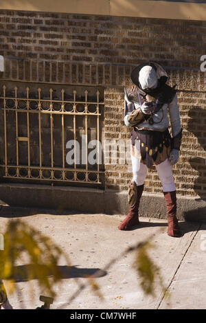 New York, USA. 22. Oktober 2012. O Positive Filme. Ein Schauspieler verkleidet als Alien verwendet ein Smartphone unterwegs eine Pause von Dreharbeiten zu einem Film auf Wadsworth Avenue im Stadtteil Manhattan in New York City Inwood Stockfoto