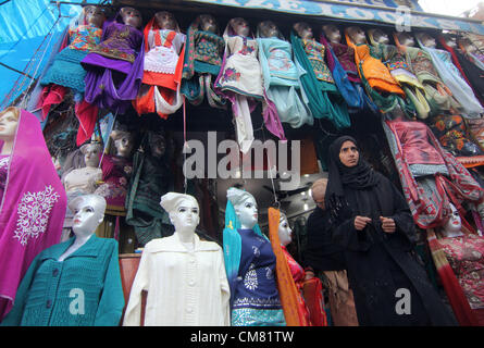 25. Oktober 2012 - ein Kashmiri muslimisches Mädchen Kleider in einem Shop in Markt vor der kommenden muslimischen Festival von Eid al-Adha in Srinagar, der Sommerhauptstadt des indischen Kaschmir auf 24.10.2012 kaufen., Moslems in Kaschmir feiert Eid am 27. Oktober. Foto/Altaf Zargar/Zuma Press (Kredit-Bild: © Altaf Zargar/ZUMAPRESS.com) Stockfoto