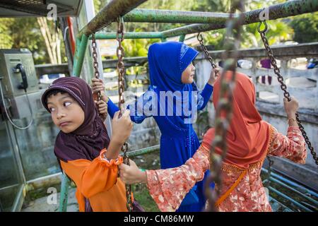 26. Oktober 2012 - Pulasaiz, Narathiwat, Thailand - Mädchen spielen auf der Schaukel im Hof einer Moschee am ersten Tag des Eid al-Adha. Eid al-Adha, auch genannt das Opferfest ist ein wichtiger religiöser Feiertag von Moslems weltweit, die Bereitschaft des Propheten Ibrahim (Abraham), seinen erstgeborenen Sohn Ismael zu opfern, als einen Akt der Unterwerfung unter Gott zu Ehren gefeiert. (Bild Kredit: Jack Kurtz/ZUMAPRESS.com ©) Stockfoto